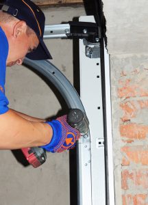 a person installing a garage door torsion springs