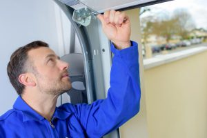 a person in blue working on how to insulate a garage door