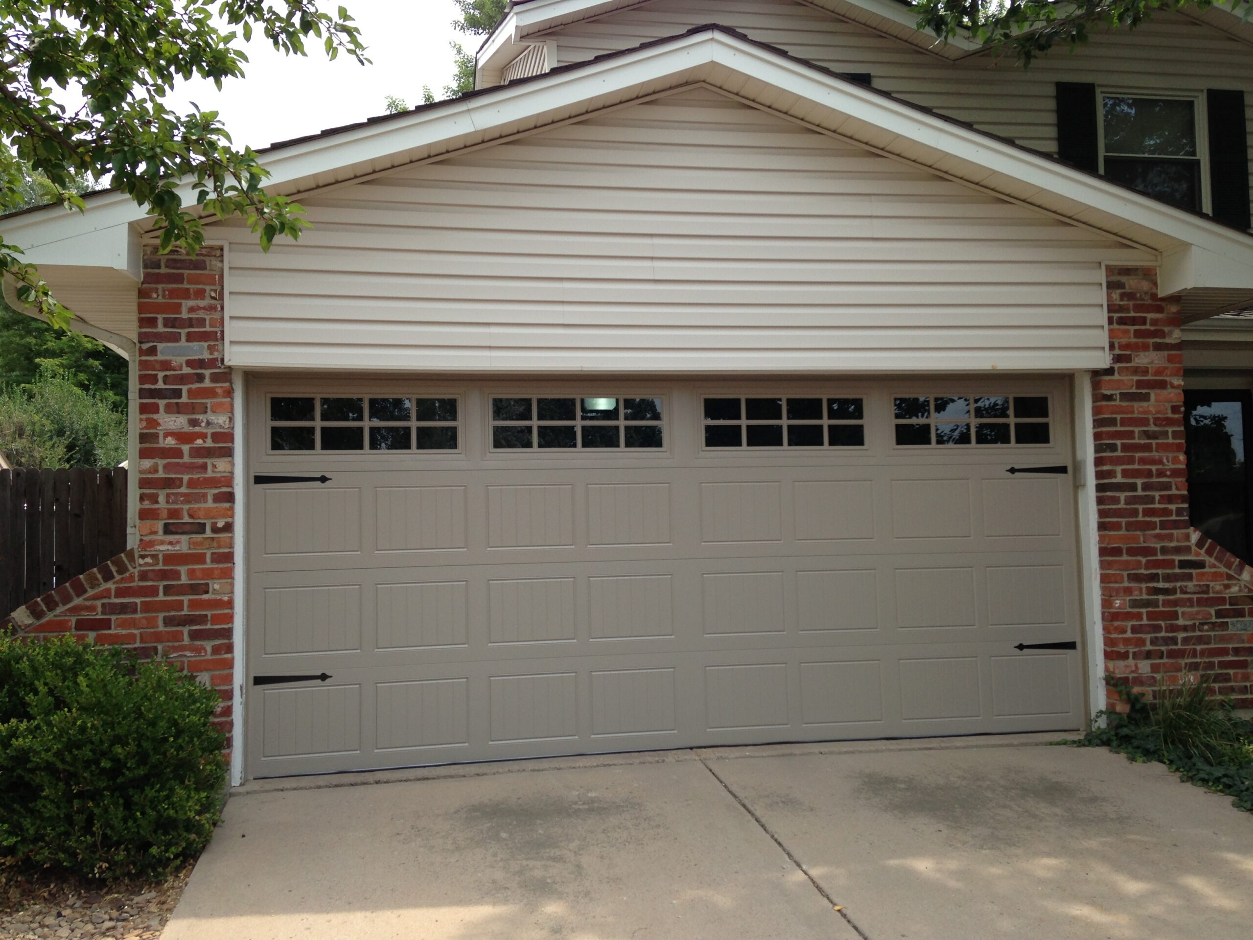 Carriage House Garage Door Installation with Decorative Hardware and Windows