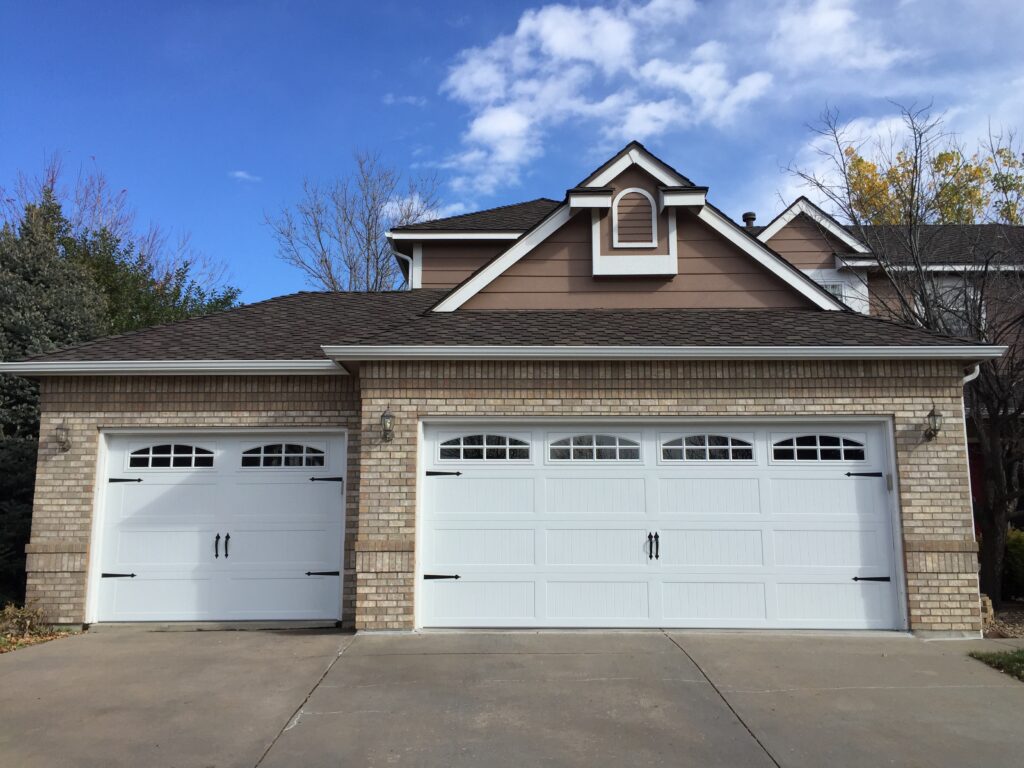 Stamped Carriage House Garage Door Upgrade with Arch Windows on Traditional Brick Suburban Home